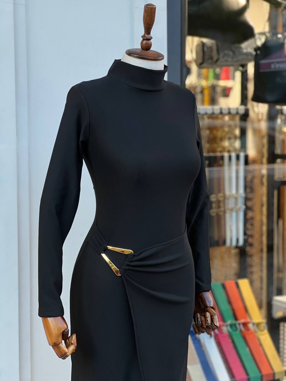 "Robe Aicha noire sophistiquée, texture brillante, fente latérale audacieuse et boucle dorée unique. Parfaite pour les soirées et événements élégants."