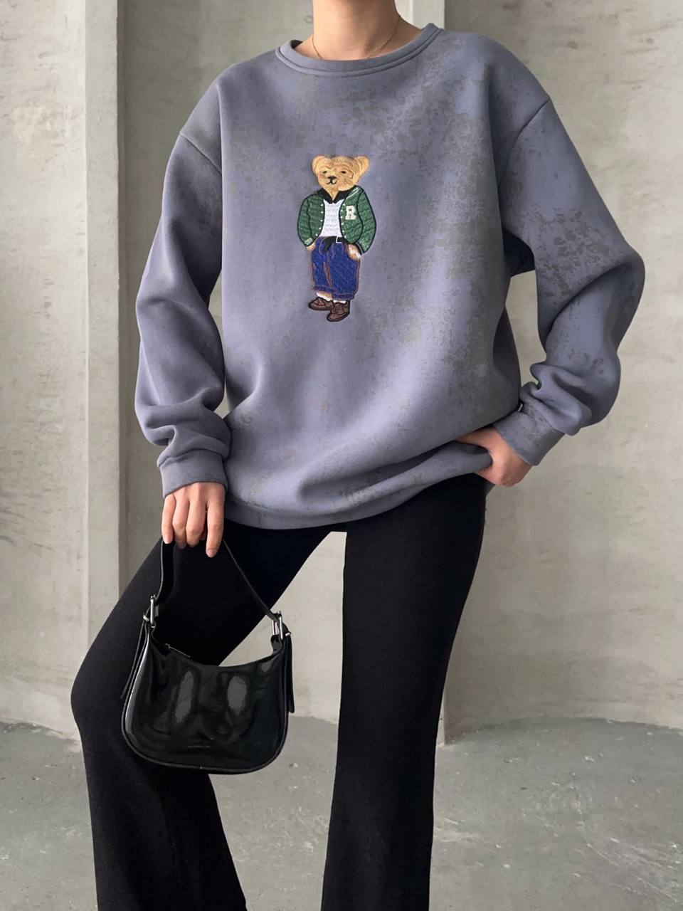 "Pull gris bleuté avec écusson nounours, intérieur molletonné, taille unique (34 à 40) pour un effet loose. Idéal pour un look confortable et tendance."